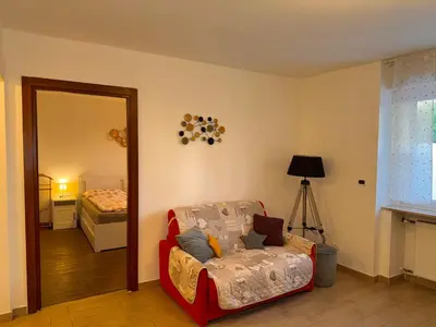 a living room with a chair and a mirror at Friedrich Apartments in Merano
