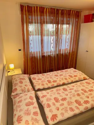 a small bedroom with a bed and a window at Friedrich Apartments in Merano