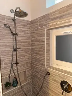 a shower with a television in a bathroom at Friedrich Apartments in Merano