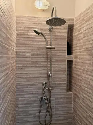 a shower with a shower head in a bathroom at Friedrich Apartments in Merano