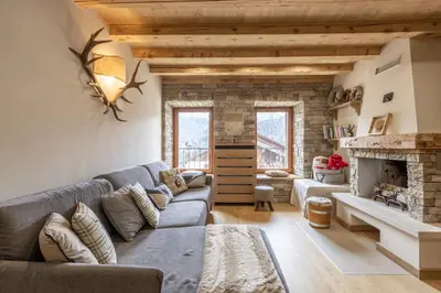 a living room with a couch and a fireplace at Casa Ladinia in San Vito di Cadore