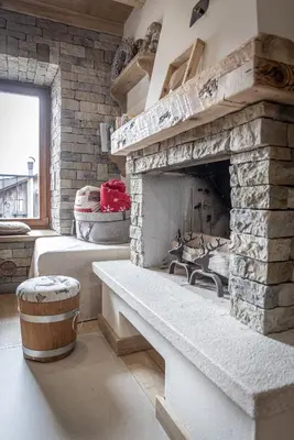 a living room with a stone fireplace with a barrel at Casa Ladinia in San Vito di Cadore