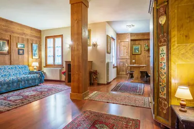 a living room with a blue couch and wooden walls at Villa S. Francesco - Stayincortina in Cortina dʼAmpezzo