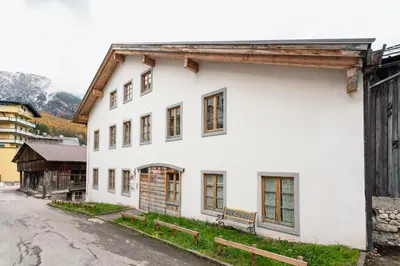 a white house with a bench on a street at Villa S. Francesco - Stayincortina in Cortina dʼAmpezzo