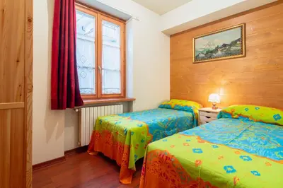 a bedroom with two beds and a window at Villa S. Francesco - Stayincortina in Cortina dʼAmpezzo