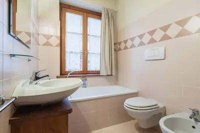 a white bathroom with a sink and a toilet at Villa S. Francesco - Stayincortina in Cortina dʼAmpezzo