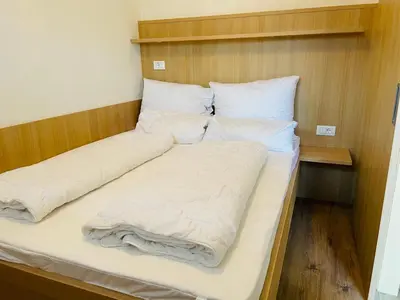 a bed with white sheets and pillows in a room at Residence Bichler in Merano