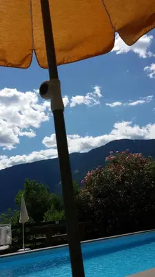 an umbrella with a view of a swimming pool at Residence Bichler in Merano