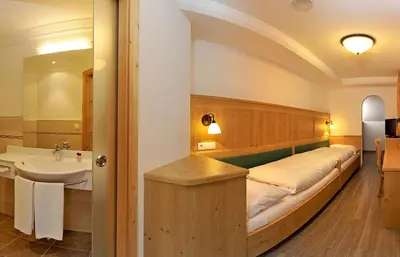 a room with a bed with a sink and a sink at Hotel Sureghes in Ortisei