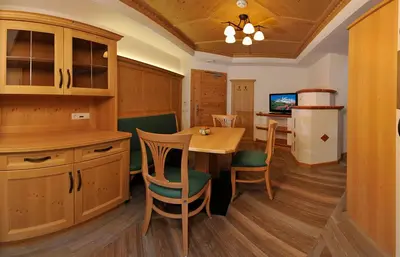 a kitchen and dining room with a table and chairs at Hotel Sureghes in Ortisei
