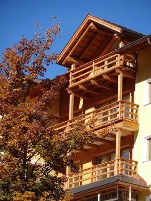 a building with wooden balconies on the side of it at Chalet Residence Alpinflair in Ortisei