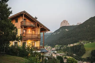 a house on a hill with a view of a valley at Chalet Residence Alpinflair in Ortisei