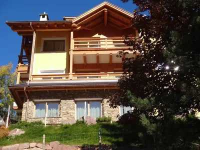 a large wooden house on top of a hill at Chalet Residence Alpinflair in Ortisei
