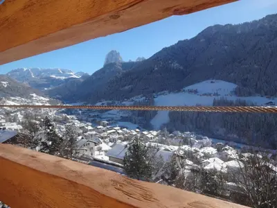 a view of a snowy mountain village from a window at Chalet Residence Alpinflair in Ortisei