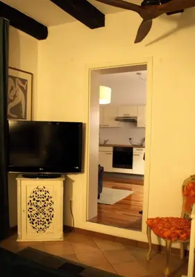 a living room with a television and a mirror at Il Florino in Merano