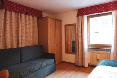 a living room with a couch and a window at Hotel Malga Passerella in Moena