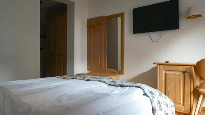a bedroom with a bed and a flat screen tv at Hotel Malga Passerella in Moena