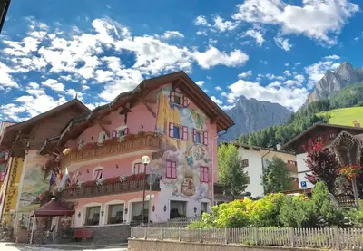 a pink building with a mural on the side of it at Park Hotel Aurora in Pozza di Fassa