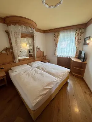 a bedroom with a large bed and a window at Park Hotel Aurora in Pozza di Fassa