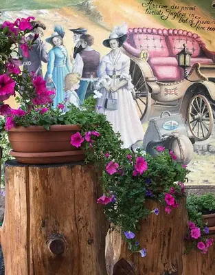 a painting of a woman with flowers on a stump at Park Hotel Aurora in Pozza di Fassa