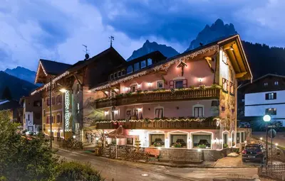a hotel in the mountains at night at Park Hotel Aurora in Pozza di Fassa