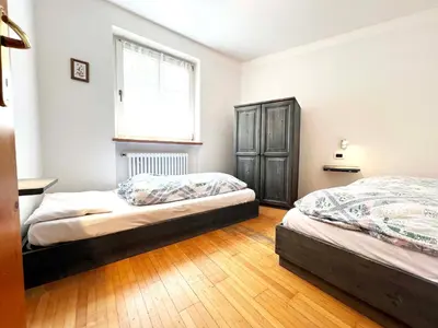 a bedroom with two beds and a window at Moena Appartamenti in Moena