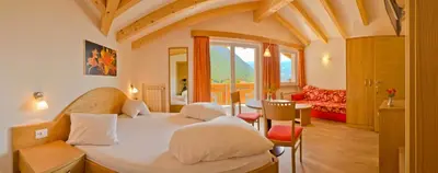 a bedroom with a bed and a living room at Plarserhof in Lagundo