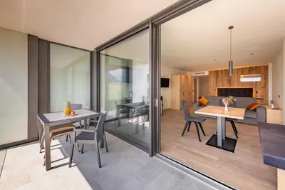 a dining room and living room with sliding glass doors at Plarserhof in Lagundo
