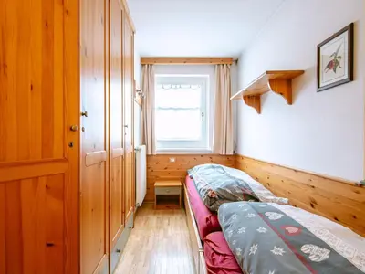 a small bedroom with a bed and a mirror at Apartment Cesa Pra da Molin-2 by Interhome in Campitello