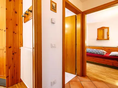 a bedroom with a bed and a wooden cabinet at Apartment Cesa Pra da Molin-2 by Interhome in Campitello