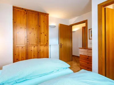 a bedroom with a bed and wooden cabinets at Apartment Cesa Pra da Molin-3 by Interhome in Campitello