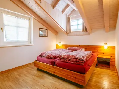 a bedroom with a wooden bed in a attic at Apartment Cesa Pra da Molin-4 by Interhome in Campitello