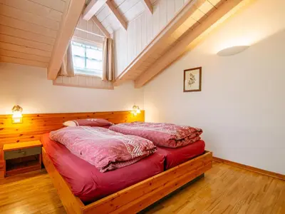 a bedroom with a bed with a red bedspread at Apartment Cesa Pra da Molin-4 by Interhome in Campitello