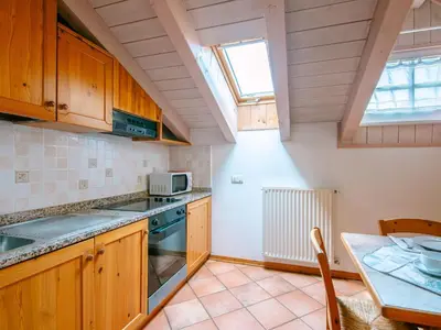 a kitchen with a wooden table and a dining room at Apartment Cesa Pra da Molin-4 by Interhome in Campitello