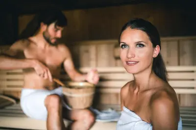 a man and a woman sitting in a bath tub at Dolasilla Mountain Panoramic Wellness Hotel in La Villa