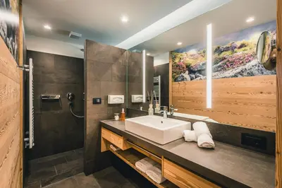 a bathroom with a sink and a mirror at Dolasilla Mountain Panoramic Wellness Hotel in La Villa