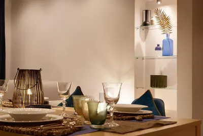 a dining table with plates and glasses on it at Franciscus Apartments in Bolzano