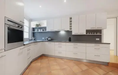 a white kitchen with white cabinets and a microwave at Franciscus Apartments in Bolzano