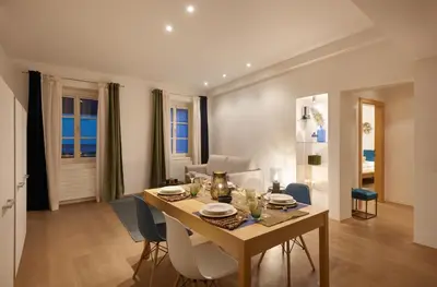 a dining room and living room with a table and chairs at Franciscus Apartments in Bolzano
