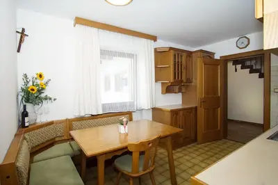 a dining room with a wooden table and a window at Home in the Alps in Racines