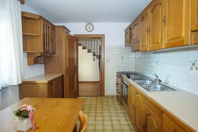 a kitchen with wooden cabinets and a wooden table at Home in the Alps in Racines