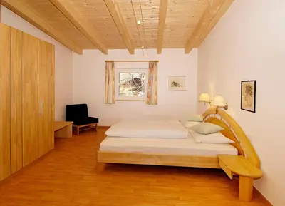 a bedroom with a bed with a wooden headboard at Residence Andrea in Lagundo