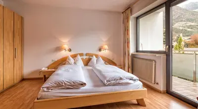 a bedroom with a bed with a large window at Residence Andrea in Lagundo