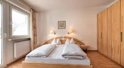 a bedroom with a bed with white pillows and a window at Residence Andrea in Lagundo