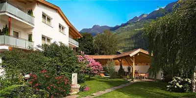 a house with a yard with flowers and a house at Residence Andrea in Lagundo