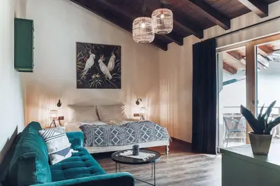 a living room with a blue couch and a bed at Botango in Parcines