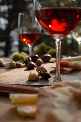 a bottle of wine and a glass of wine and some nuts at Fewo Zweiraum im Haus Götsch 5 in Parcines