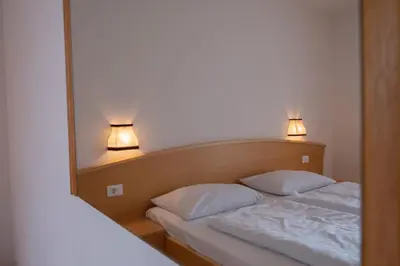 a bedroom with a bed with two pillows and a mirror at Fewo Zweiraum im Haus Götsch 5 in Parcines