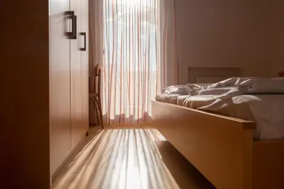 a bedroom with a bed and a large window at Fewo Zweiraum im Haus Götsch 5 in Parcines