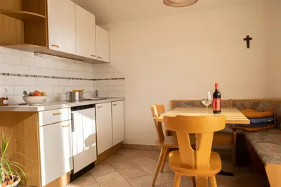 a kitchen with a table with a bottle of wine at Fewo Zweiraum im Haus Götsch 5 in Parcines